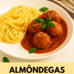 Almôndegas ao sugo caseiras servidas em um prato fundo branco ao lado de espaguete, cobertas com molho de tomate, queijo parmesão ralado e folhas frescas de manjericão.