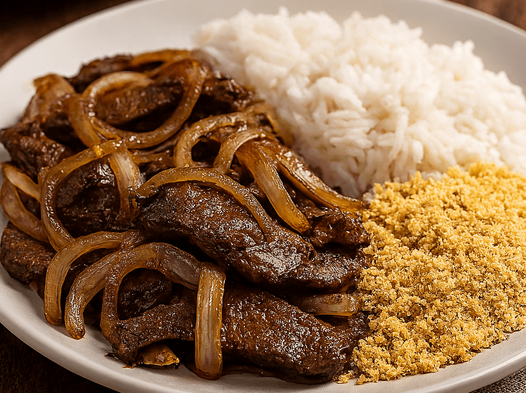 Iscas de fígado aceboladas com bastante cebola dourada, servidas em um prato branco ao lado de arroz branco soltinho e farofa amarela.