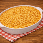 Travessa de vidro recém-saída do forno com fricassê de atum borbulhante, cobertura de queijo muçarela gratinado bem douradinho e bastante batata palha extrafina por cima.