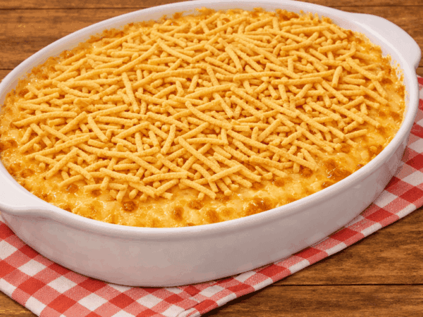 Travessa de vidro recém-saída do forno com fricassê de atum borbulhante, cobertura de queijo muçarela gratinado bem douradinho e bastante batata palha extrafina por cima.